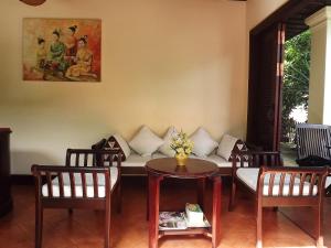 a living room with a couch and a table and chairs at Villa Le Tam Tam Boutique Hotel in Luang Prabang
