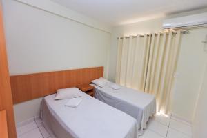 2 camas en una habitación pequeña con ventana en Golden Dolphin Grand Hotel via Hmaster, en Caldas Novas