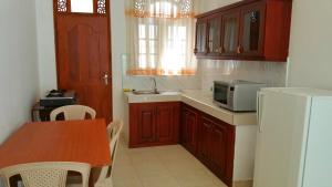 a small kitchen with a table and a microwave at Holiday Fashion Inn in Negombo