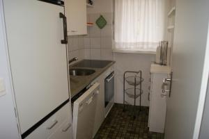 a small kitchen with white cabinets and a sink at Valbella in Davos