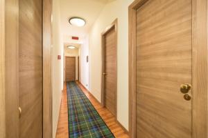 un corridoio con porta in legno e un pavimento di Hotel Bernardino a Lucca
