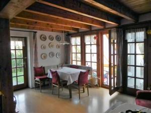 een eetkamer met een tafel, stoelen en ramen bij Haus Luise in Homberg