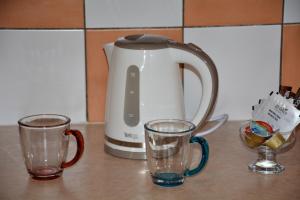 a tea kettle and two glasses on a counter at Town Apartment & Studio in Argostoli
