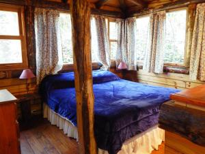 a bedroom with a four poster bed in a cabin at Las Terrazas Resort & Apart-Cabañas in La Falda +154 photos