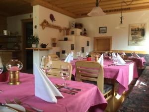 a restaurant with pink tables and chairs with wine glasses at Oimrausch in Ramingstein