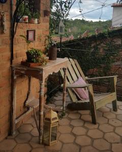 a table and a wooden bench with a table and a chair at hostelvi guesthouse in Lençóis