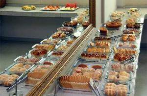 a display case filled with lots of different types of pastries at Hotel Primavera in Bom Despacho