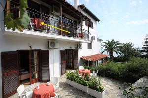 a house with a table and chairs on a balcony at Villa Melia in Vassilias