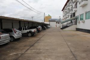 a parking lot with cars parked next to a building at Hotel Primavera in Bom Despacho