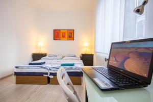 a laptop computer sitting on a desk in a room with a bed at Andrássy Apartment with Inside Parking in Budapest