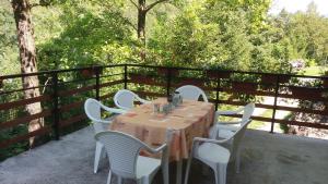 a table with white chairs sitting on a balcony at Apartment Sela in Tolmin