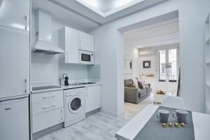 een keuken en een woonkamer met een wasmachine en droger bij LEEWAYS LOFT I in HORTALEZA in Madrid