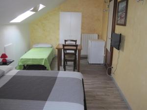 a room with two beds and a desk and a table at La Mansarda di Legno in Turin