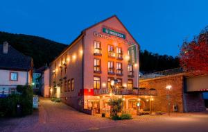 um grande edifício com luzes na lateral em Hotel Goldenes Fass em Freudenberg am Main