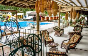 un complejo con piscina, sillas y piscina en Hotel Mundaí Praia Camping e Est para Mh en Porto Seguro