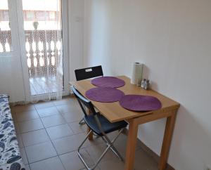 - une table en bois avec des tapis violets dans l'établissement Studio Alex, à Poiana Brasov