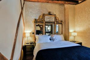 ein Schlafzimmer mit einem Bett mit einer Uhr an der Wand in der Unterkunft Le B. Suites, Chambres & Restaurant in Riquewihr