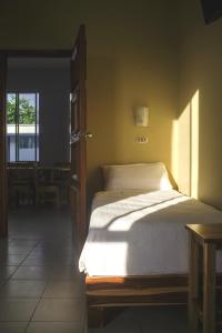 um quarto com uma cama, uma mesa e uma janela em Pizzeria Colisseo B & B em Jinotepe