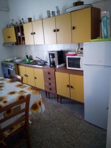 una cucina con armadi gialli e frigorifero bianco di Affitti Brevi Mamoiada Centro a Mamoiada