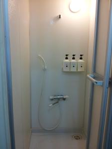 a bathroom with a shower with two bottles on the wall at Business Hotel Taiyo in Osaka