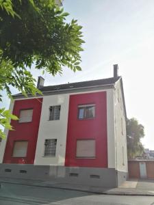 ein rot-weißes Gebäude an der Straßenseite in der Unterkunft Zu Hause Bei Freunden in Dortmund