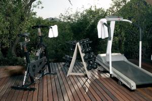a treadmill and a bike on a wooden deck at Etali Safari Lodge in Madikwe Game Reserve