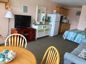 a living room with a dining room table and a television at Lollipop Motel in North Wildwood