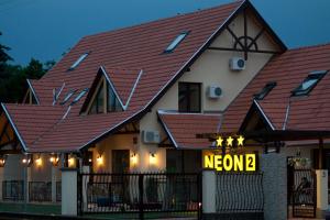 a house with a sign that reads new at Neon2 - Vendégház in Orosháza