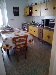 eine Küche mit einem Tisch und eine Küche mit gelben Schränken in der Unterkunft Affitti Brevi Mamoiada Centro in Mamoiada