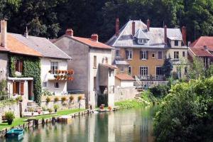 Chambres d'hôtes Notre Paradis في Dun-sur-Meuse: مجموعة منازل بجانب نهر