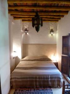 - une chambre avec un grand lit et un lustre dans l'établissement Riad Cascades d'Ouzoud, à Ouzoud