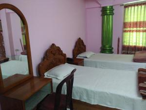 ein Schlafzimmer mit zwei Betten und einem Spiegel in der Unterkunft Hotel Green Castle in Rangamati