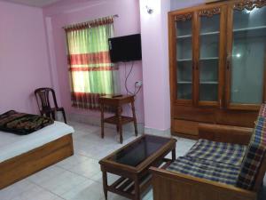 ein Zimmer mit einem Bett, einem Stuhl und einem Fernseher in der Unterkunft Hotel Green Castle in Rangamati