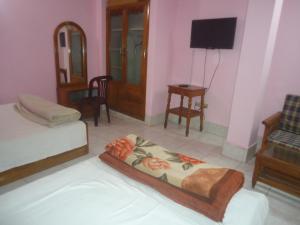 ein Zimmer mit Bett, Fernseher und Stühlen in der Unterkunft Hotel Green Castle in Rangamati + 6 Fotos