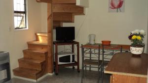 sala de estar con escalera, TV y microondas en Departamentos Arlenne II, en Valdivia