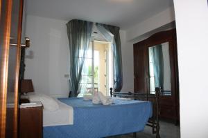 a bedroom with a bed with blue sheets and a mirror at Patrancarro Home - Letojanni Taormina in Letojanni