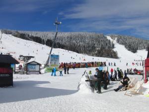 un grupo de personas en una pista de esquí cubierta de nieve en Apartments Sport Fudel, en Kurort Oberwiesenthal