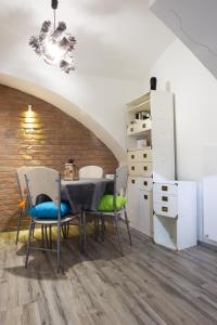 Apartman Vita في زغرب: غرفة طعام مع طاولة وكراسي وجدار من الطوب