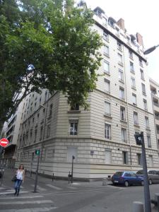 a woman walking in front of a large building at au 303 in Lyon