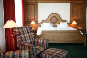ein Schlafzimmer mit einem Bett, einem Stuhl und einem Bett in der Unterkunft Maifeld Sport- und Tagungshotel in Werl