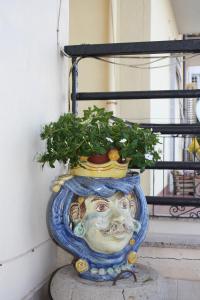 eine Gesichtsstatue mit einer Pflanze darin in der Unterkunft Patrancarro Home in Letojanni