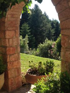 an archway with a potted plant in a garden at Aphrodite's Inn Kalavrita in Kalavrita +119 photos