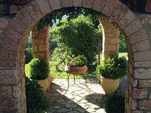 an archway with two potted plants in a yard at Aphrodite's Inn Kalavrita in Kalavrita