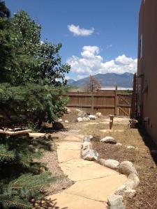 a garden with a stone walkway next to a fence at Adorable Taos Townhome in Taos