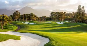 a view of a golf course with mountains in the background at 1 Hotel Hanalei Bay in Princeville
