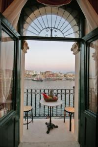 a table with a bowl of fruit on a balcony at Casa Leone Hotel in Chania