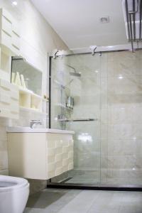 a bathroom with a shower and a sink and a toilet at Hotel MUSE in Sankt Pölten