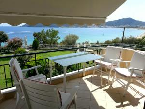 balcón con mesa, sillas y vistas al océano en Villa Eirini, en Nea Iraklitsa