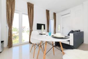 biała jadalnia z białym stołem i krzesłami w obiekcie Apartments Tija Exclusive w mieście Zadar