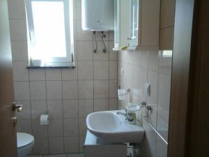 ein Badezimmer mit Waschbecken, Toilette und Fenster in der Unterkunft Apartment Andjel in Poreč + 37 Fotos
